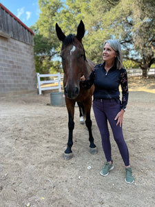 Woman standing with horse in a Kastel shirt and HKM purple breeches